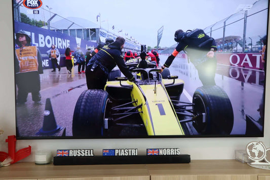 F1 team members working on a race car during a wet race, showcasing an exciting motorsport scene.