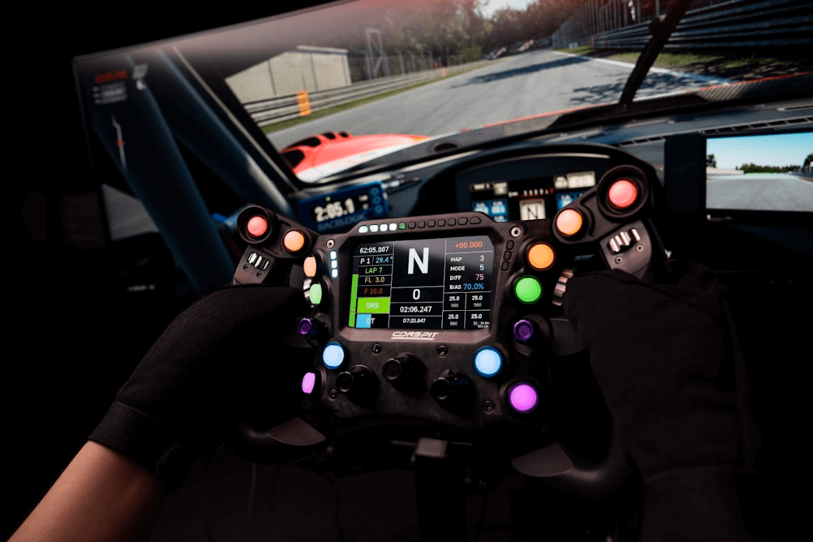 Close-up of racing simulator steering wheel with colorful buttons and display, enhancing the sim racing experience.
