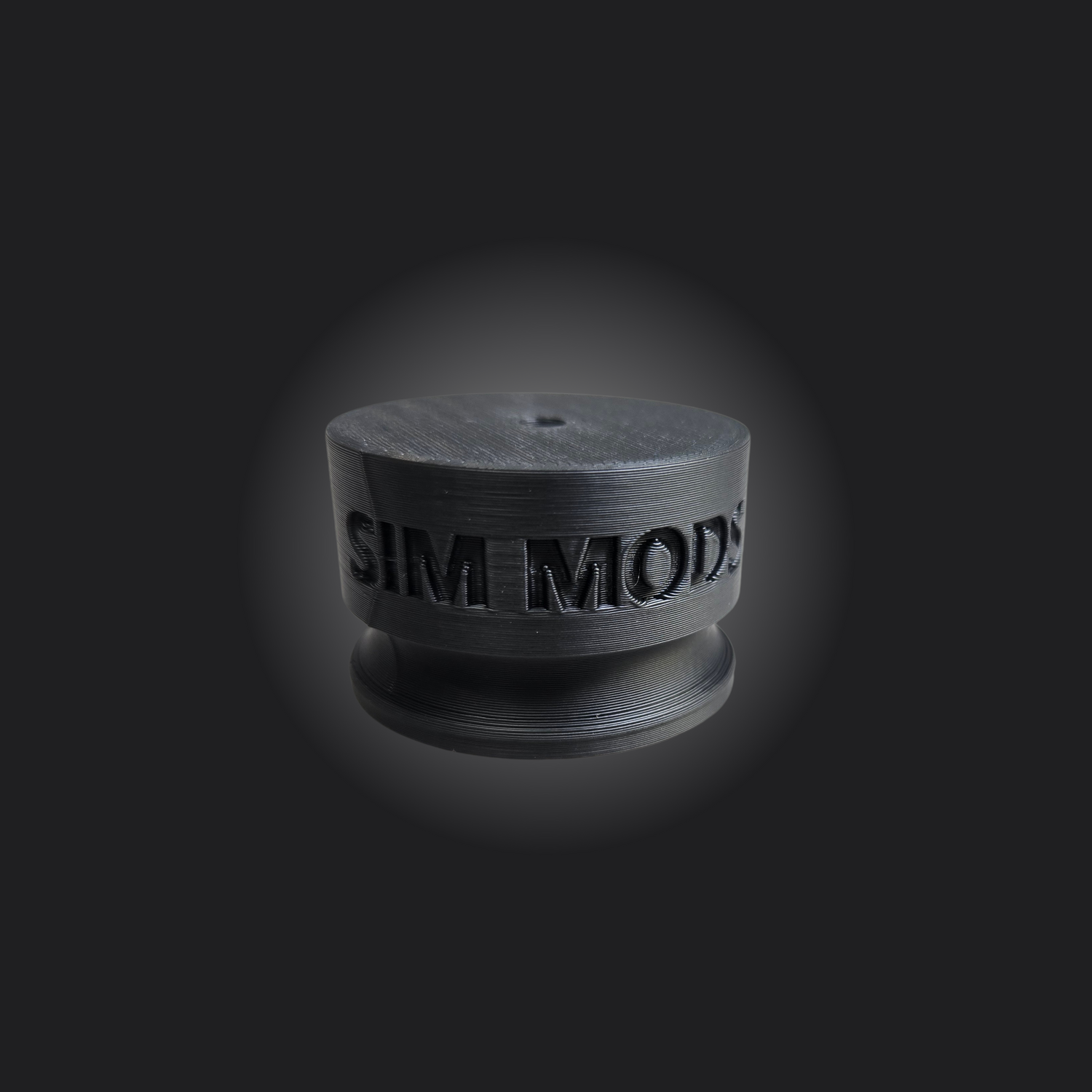 Close-up of a black Sim Mods accessory for sim racing gear.